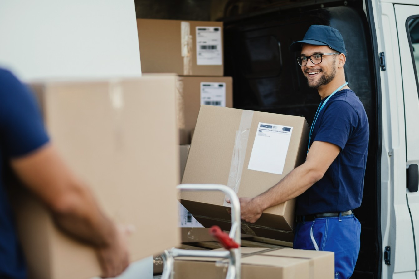 Delivery worker loading boxes into a van